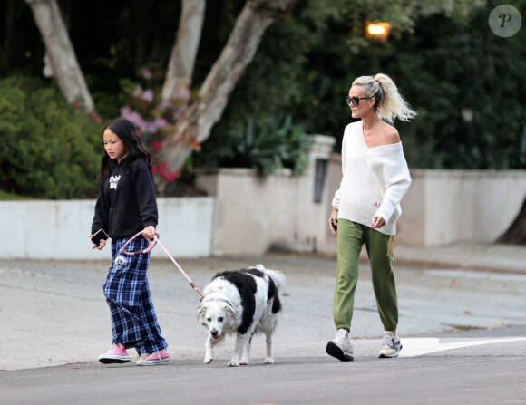 Laeticia Hallyday et ses filles Jade, 15 ans, et Joy, 11 ans, promènent leur chien Cheyenne dans le quartier de Brentwood à Los Angeles, pendant la période de confinement liée à l'épidémie de coronavirus (Covid-19), le 1er avril 2020.