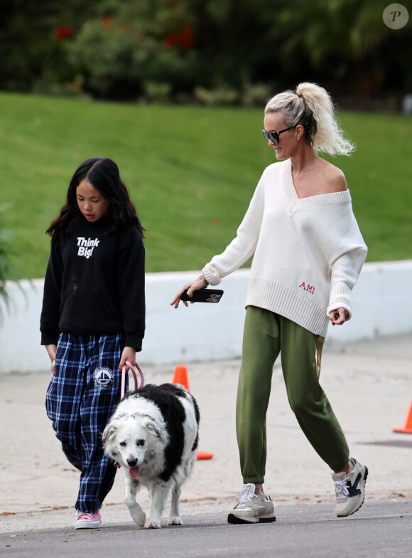 Laeticia Hallyday et ses filles Jade, 15 ans, et Joy, 11 ans, promènent leur chien Cheyenne dans le quartier de Brentwood à Los Angeles, pendant la période de confinement liée à l'épidémie de coronavirus (Covid-19), le 1er avril 2020.