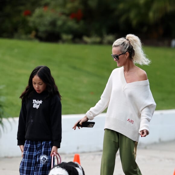 Laeticia Hallyday et ses filles Jade, 15 ans, et Joy, 11 ans, promènent leur chien Cheyenne dans le quartier de Brentwood à Los Angeles, pendant la période de confinement liée à l'épidémie de coronavirus (Covid-19), le 1er avril 2020.