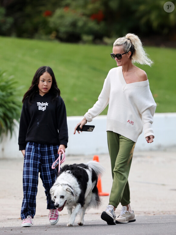 Laeticia Hallyday et ses filles Jade, 15 ans, et Joy, 11 ans, promènent leur chien Cheyenne dans le quartier de Brentwood à Los Angeles, pendant la période de confinement liée à l'épidémie de coronavirus (Covid-19), le 1er avril 2020.