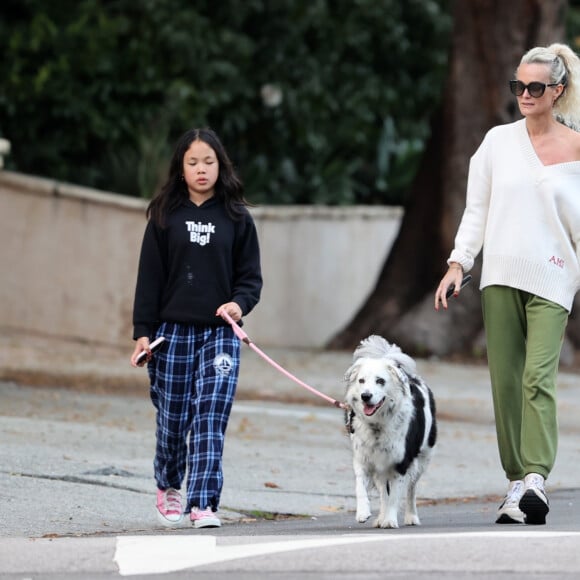 Laeticia Hallyday et ses filles Jade, 15 ans, et Joy, 11 ans, promènent leur chien Cheyenne dans le quartier de Brentwood à Los Angeles, pendant la période de confinement liée à l'épidémie de coronavirus (Covid-19), le 1er avril 2020.