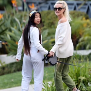 Laeticia Hallyday et ses filles Jade, 15 ans, et Joy, 11 ans, promènent leur chien Cheyenne dans le quartier de Brentwood à Los Angeles, pendant la période de confinement liée à l'épidémie de coronavirus (Covid-19), le 1er avril 2020.