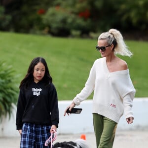 Laeticia Hallyday et ses filles Jade, 15 ans, et Joy, 11 ans, promènent leur chien Cheyenne dans le quartier de Brentwood à Los Angeles, pendant la période de confinement liée à l'épidémie de coronavirus (Covid-19), le 1er avril 2020.