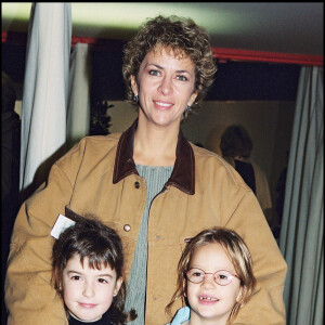 Archives- Corinne Touzet et ses filles Jeanne et Claire à Bercy, le 26 novembre 2000.