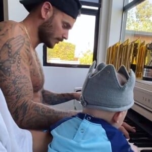 M. Pokora au piano avec son fils Isaiah. Le chanteur français est confiné à Los Angeles avec sa famille. Le 6 mai 2020.