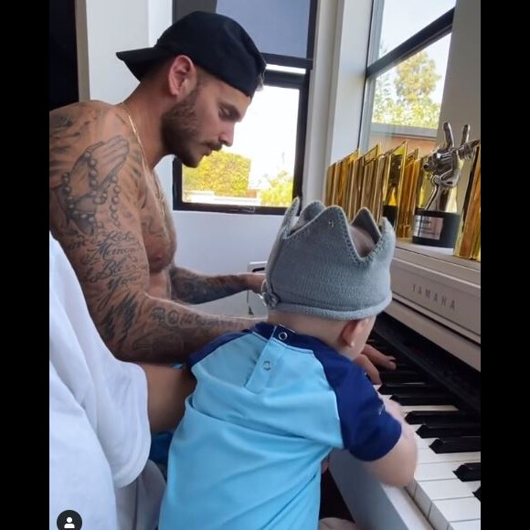M. Pokora au piano avec son fils Isaiah. Le chanteur français est confiné à Los Angeles avec sa famille. Le 6 mai 2020.