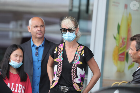 Laeticia Hallyday et ses filles Jade et Joy arrivent, avec des masques de protection contre l'épidémie de coronavirus (Covid-19), à l'aéroport de Paris-Charles-de-Gaulle à Roissy-en-France, France, le 18 juin 2020.