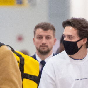 Exclusif - Brooklyn Beckham et sa compagne Nicola Peltz portent des masques assortis à leur arrivée à l'aéroport JFK de New York le 9 mars 2020.