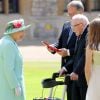 La reine Elisabeth II d'Angleterre remet au capitaine Thomas Moore son titre de chevalier lors d'une cérémonie au château de Windsor, le 17 juillet 2020.