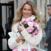 Celine Dion rayonnante et très souriante dans un ensemble pull écru et jupe bouffante fleurie salue ses fans à la sortie de son hôtel à New York, le 8 mars 2020