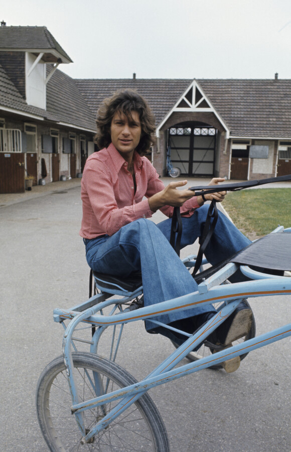 En France, Mike Brant, chanteur, avec son cheval Kullebert dans un haras en juin 1974. Michel Ristroph via Bestimage