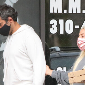 Exclusif - Lady Gaga et son compagnon Michael Polansky sont allés acheter leur dîner à emporter dans un restaurant à Malibu, le 27 juin 2020. Elle porte un sweat oversize (sans pantalon) et un masque de protection contre le Coronavirus (Covid-19) rose assorti à son sac à dos