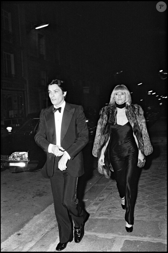 Alain Delon et Mireille Darc arrivent à une soirée à Paris en 1975.
