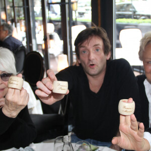 Exclusif - Catherine Lara, Pierre Palmade et Muriel Robin posent avec des ronds de serviettes en bois Banana's avec leurs prénoms lors du déjeuner d'anniversaire de Pierre Palmade au restaurant Le Fouquet's à Paris, le 30 mars 2015.