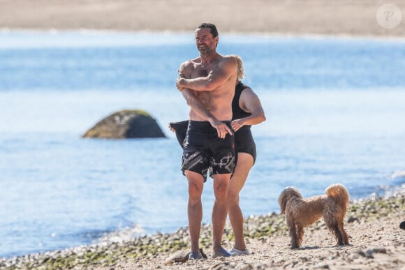 Exclusif - Hugh Jackman se balade sur la plage avec sa femme Deborra Lee Furness et ses chiens sous le soleil des Hamptons, le 25 juillet 2020