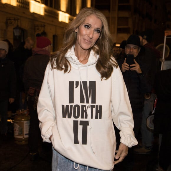 Céline Dion porte un sweat blanc à capuche avec l'inscription "I'M WORTH IT" (Je le vaux bien) à la sortie de l'hôtel Plaza Athénée après le tournage pour l'Oréal à Paris, France