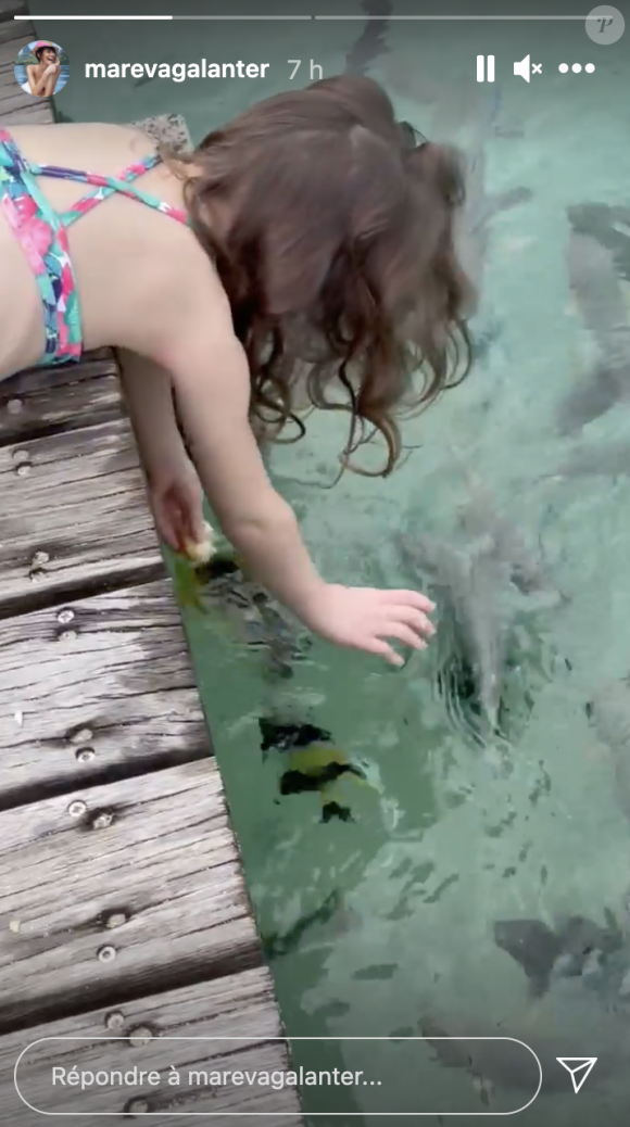 Manava, la fille d'Arthur et Mareva Galanter, s'amuse avec les poissons à Tahiti, le 21 décembre 2020.