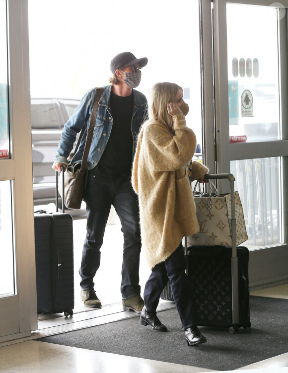 Exclusif - Emma Roberts, enceinte et son compagnon Garrett Hedlund au départ de l'aéroport LAX avec leurs valises Louis Vuitton. Ils portent des masques pour se protéger de l'épidémie de Coronavirus (COVID-19).