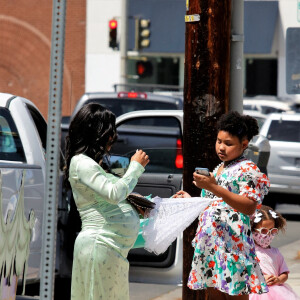 Christina Milian, enceinte, et sa fille Violet font la promotion de la marque "Beignet Box" de Christina sur un char lors d'une parade à Los Angeles le 10 avril 2021.