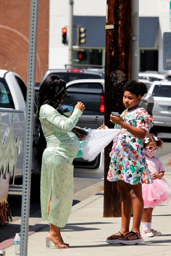 Christina Milian, enceinte, et sa fille Violet font la promotion de la marque "Beignet Box" de Christina sur un char lors d'une parade à Los Angeles le 10 avril 2021.