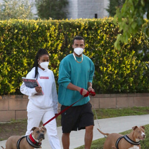 Jesse Williams ("Grey's Anatomy") et sa compagne Taylour Paige, équipés de masques de protection, promènent leurs chiens pendant l'épidémie de coronavirus (Covid-19) à Los Angeles, le 16 avril 2020.