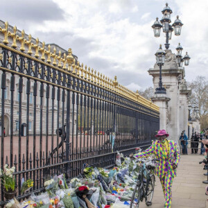 Les Anglais viennent rendrent hommage au prince Philip, duc d'Edimbourg devant les grilles de Buckingham Palace à Londres le 11 avril 2021.