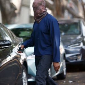 Exclusif - Kanye West se protège de la canicule en portant une cagoule sur la tête dans la rue à Los Angeles le 15 juin 2021.