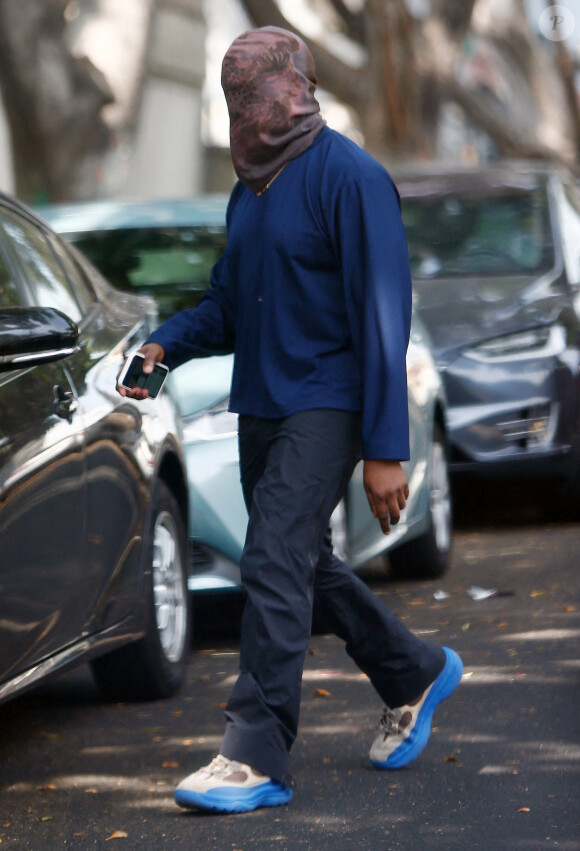 Exclusif - Kanye West se protège de la canicule en portant une cagoule sur la tête dans la rue à Los Angeles le 15 juin 2021.