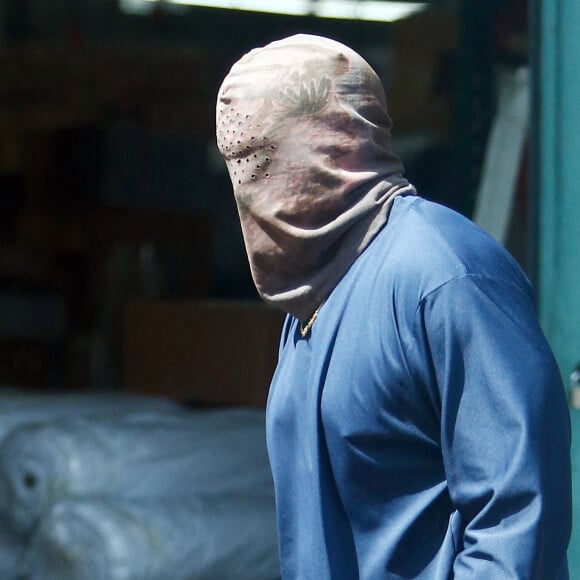 Exclusif - Kanye West se protège de la canicule en portant une cagoule sur la tête dans la rue à Los Angeles le 15 juin 2021.