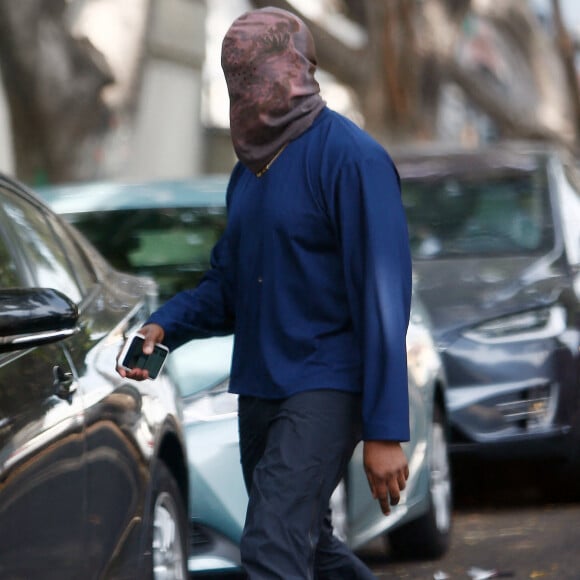 Exclusif - Kanye West se protège de la canicule en portant une cagoule sur la tête dans la rue à Los Angeles le 15 juin 2021.