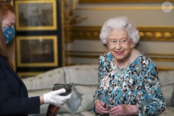 La reine Elisabeth II d'Angleterre découvre le bâton des Jeux du Commonwealth de Birmingham 2022 au palais de Buckingham à Londres, Royaume Uni, le 7 octobre 2021.