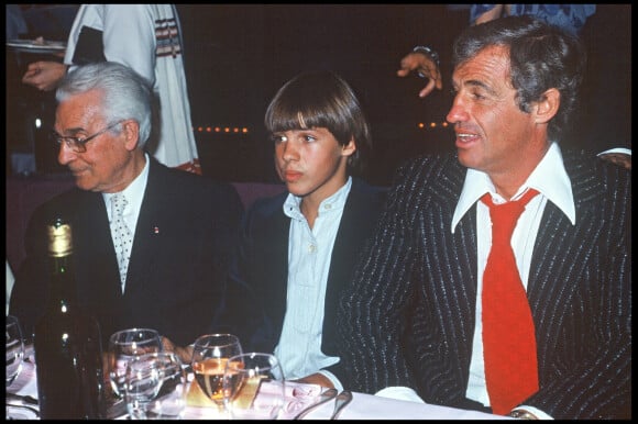Archives - Jean-Paul Belmondo fête ses 20 ans de cinéma lors d'un dîner avec son père Paul et son fils Paul. 1977.