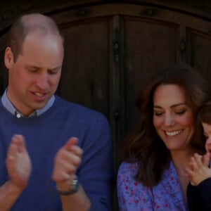 Captures d’écran d’une vidéo inédite de la famille royale dévoilée lors d'un sketch hilarant avec le prince William et Stephen Fry. L'humour anglais dans toute sa splendeur. Ce jeudi 23 avril, pour un sketch qui visait à récolter des fonds pour le personnel soignant britannique, le prince William a accepté de jouer la comédie avec le renommé Stephen Fry. A la fin de la vidéo, on a pu voir le prince se réunir avec Kate Middleton et leurs trois enfants, George, Charlotte et Louis devant chez eux pour applaudir le personnel soignant.  London, UNITED KINGDOM - The Duke and Duchess of Cambridge and their children join the UK in cheering frontline workers during the coronavirus emergency 