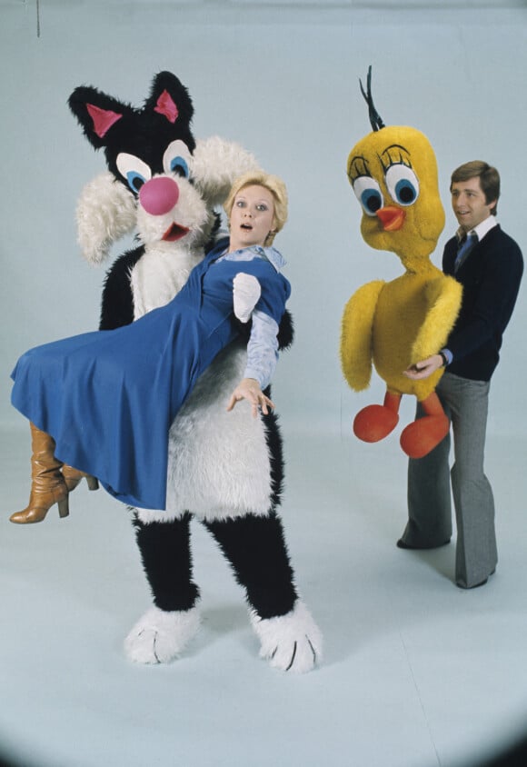 Sophie Darel dans les bras du personnage de Gros Minet, au côté de Bernard Golay portant le personnage de Titi. Novembre 1975