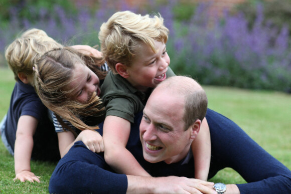 Le prince William et ses trois enfants, le prince George, la princesse Charlotte et le prince Louis, dans leur jardin d'Anmer Hall (Norfolk). Photo prise par Kate Middleton pour les 38 ans du prince et la fête des Pères, en juin 2020.
