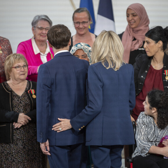 Le président Emmanuel Macron et la première dame Brigitte Macron lors de la cérémonie de remise de la médaille de l'Enfance et des Familles au palais de l'Elysée à Paris le 16 mars 2022