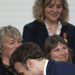Le président Emmanuel Macron et la première dame Brigitte Macron lors de la cérémonie de remise de la médaille de l'Enfance et des Familles au palais de l'Elysée à Paris le 16 mars 2022