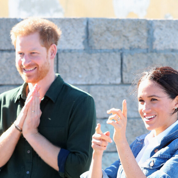 Le prince Harry, duc de Sussex, et Meghan Markle, duchesse de Sussex rencontrent les membres de "Waves for Change" un organisme de bienfaisance qui travaille avec les surfeurs locaux sur la plage de Monwabisi au Cap lors de leur 2ème journée en Afrique du Sud, le 24 septembre 2019. 