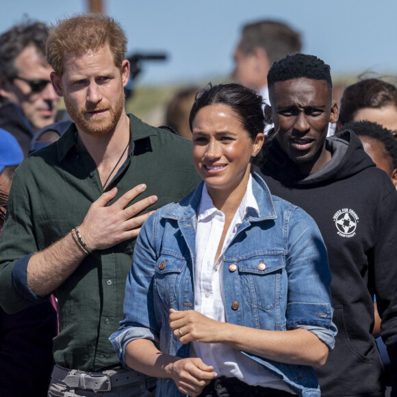 Le prince Harry, duc de Sussex, et Meghan Markle, duchesse de Sussex rencontrent les membres de "Waves for Change" un organisme de bienfaisance qui travaille avec les surfeurs locaux sur la plage de Monwabisi au Cap lors de leur 2ème journée en Afrique du Sud, le 24 septembre 2019. 