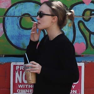 Exclusif - Lily Rose Depp fait une pause cigarette avec une amie après le brunch à Los Angeles, le 27 février 2022.