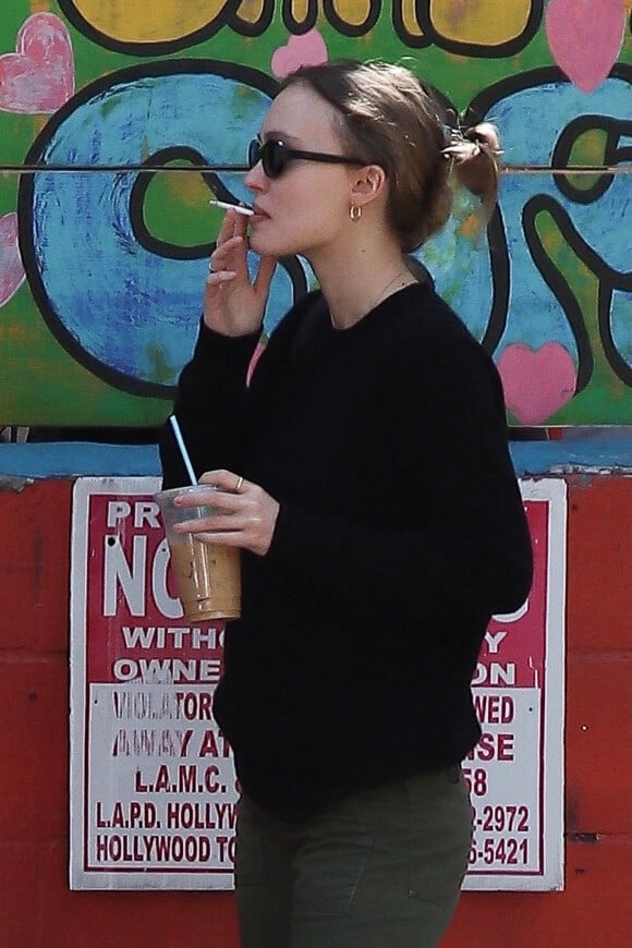 Exclusif - Lily Rose Depp fait une pause cigarette avec une amie après le brunch à Los Angeles, le 27 février 2022.