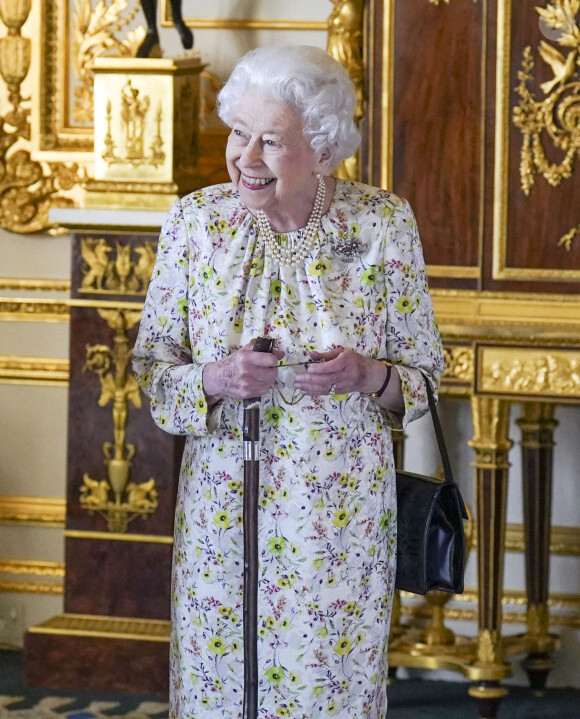 La reine Elizabeth II d'Angleterre parcourt l'exposition d'objets de la société d'artisanat britannique Halcyon Days, pour marquer son jubilé de platine, au château de Windsor, le 23 mars 2022.