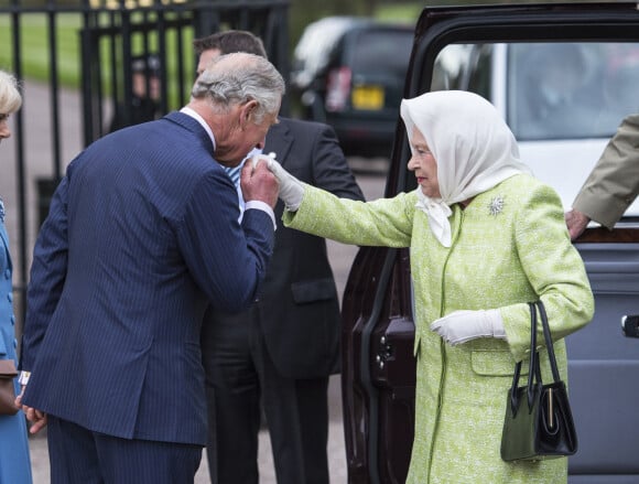 La reine Elisabeth II d'Angleterre, accompagnée de son fils le prince Charles, allume un flambeau au château de Windsor, à l'occasion de son 90ème anniversaire. Le 21 avril 2016