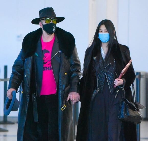 Nicolas Cage et sa femme Riko Shibata arrivent, main dans la main, à l'aéroport JFK à New York, le 27 novembre 2021.
