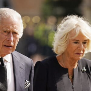 Le roi Charles III d'Angleterre et Camilla, reine consort d'Angleterre, saluent la foule aux abords du château de Hillsborough à Belfast, le 13 septembre 2022.