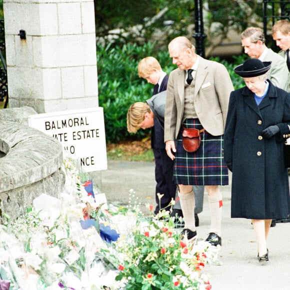 La reine Elisabeth II d'Angleterre et le prince Philip, duc d'Edimbourg, le prince Charles et ses fils le prince William et le prince Harry, devant l'entrée du château de Balmoral, où de nombreux hommages ont été rendues suite à la mort de la princesse Diana. Le 5 septembre 1997 