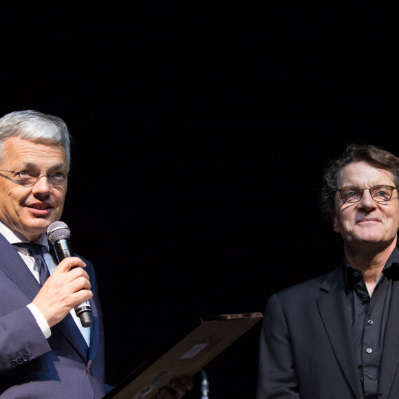 Francis Cabrel reçoit la décoration d'officier de l'ordre de la Couronne par le vice-premier ministre et ministre des affaires étrangères Didier Reynders lors de son concert au Palais 12 à Bruxelles, le 15 avril 2014. Sa mère Denise Nin et sa femme Mariette sont venues l'applaudir. 