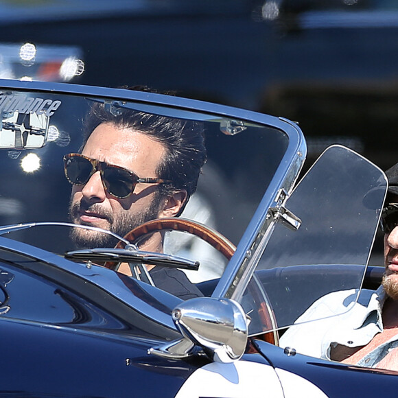 Johnny Hallyday accompagné de Maxim Nucci (Yodelice), arrive au restaurant "Soho House" à Malibu, au volant de son cabriolet AC Cobra marqué de son chiffre porte-bonheur, le numéro 7. Malibu, le 09 mars 2017.