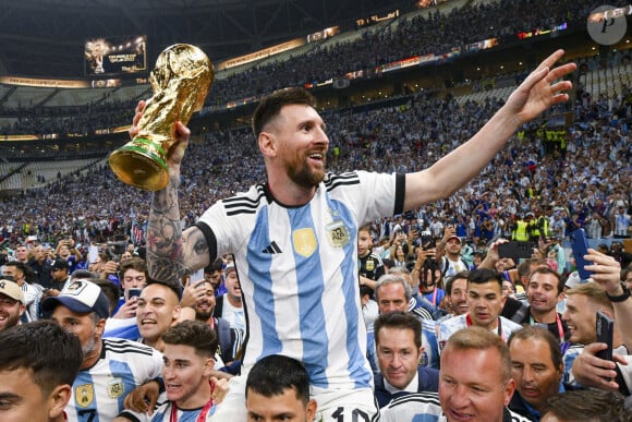 Lionel Messi soulevant le trophee de la Coupe du Monde et porte en triomphe par ses coequipiers - Remise du trophée de la Coupe du Monde 2022 au Qatar (FIFA World Cup Qatar 2022) à l'équipe d'argentine après sa victoire contre la France en finale (3-3 - tab 2-4). Doha, le 18 décembre 2022.