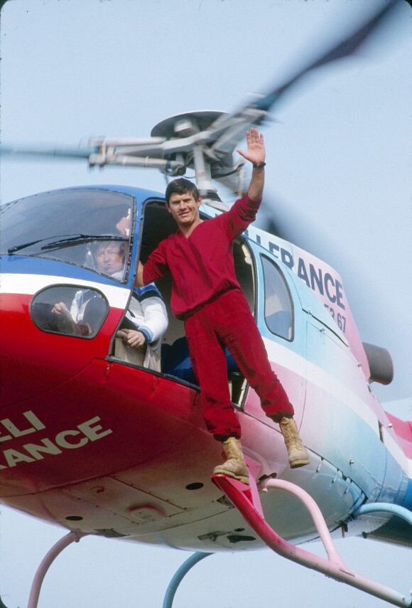 Archives - En France, Philippe de Dieuleveult debout sur le marche-pied d'un hélicoptère lors de l'émission La chasse aux trésors en mars 1983